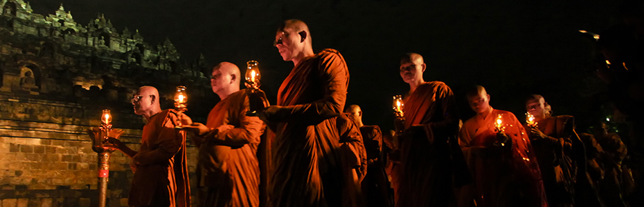 Les moines bouddhistes, reconnaissables à leur robe safran, portent un bougie durant la procession, symbole de l'accès au nirvana 